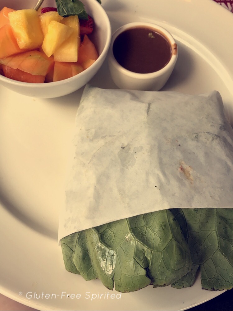 A picture of a grilled chicken sandwich, a bowl of balsamic vinegar, and a bowl of fruit at YardHouse.