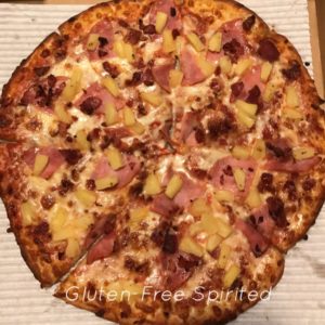 Gluten-free pizza crust with pineapple and bacon.