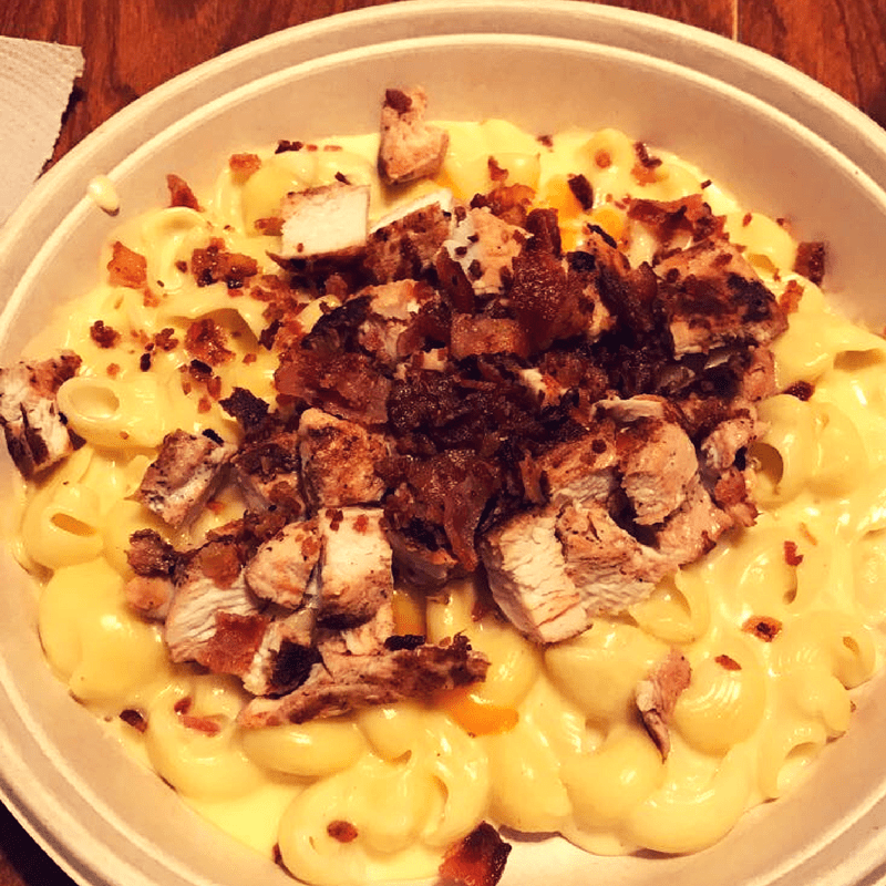 Chicken macaroni & cheese with bacon on a white pita.