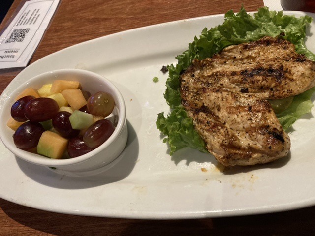 Grilled Chicken on lettuce with bowl of fresh fruit